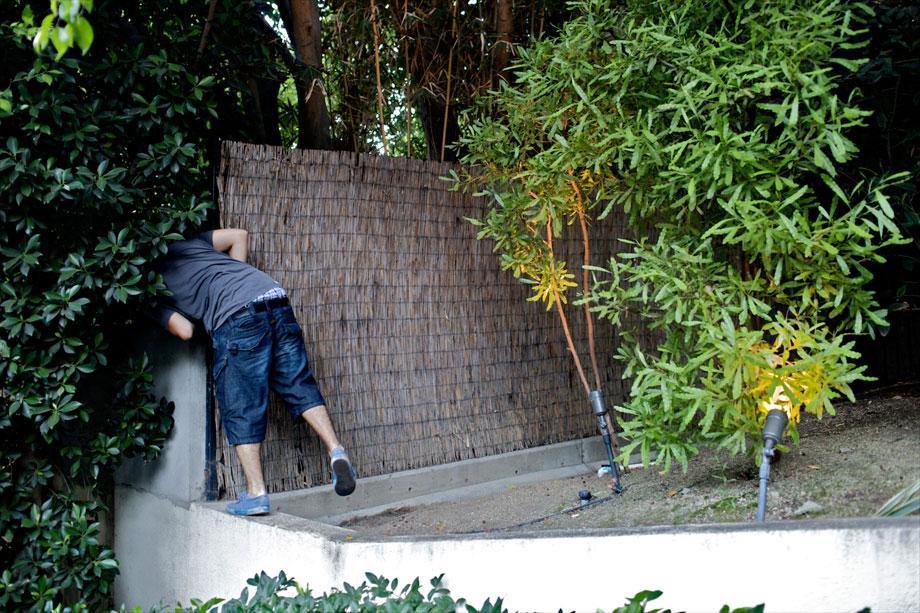 Ben looks for a car behind the wall of a celebrity's home in Los Angeles, Aug. 5, 2009. 