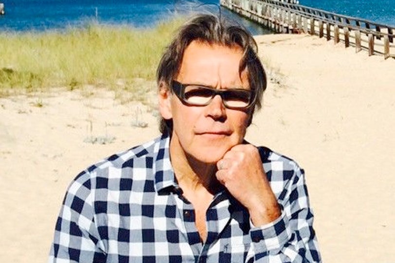 A man in glasses on the beach.