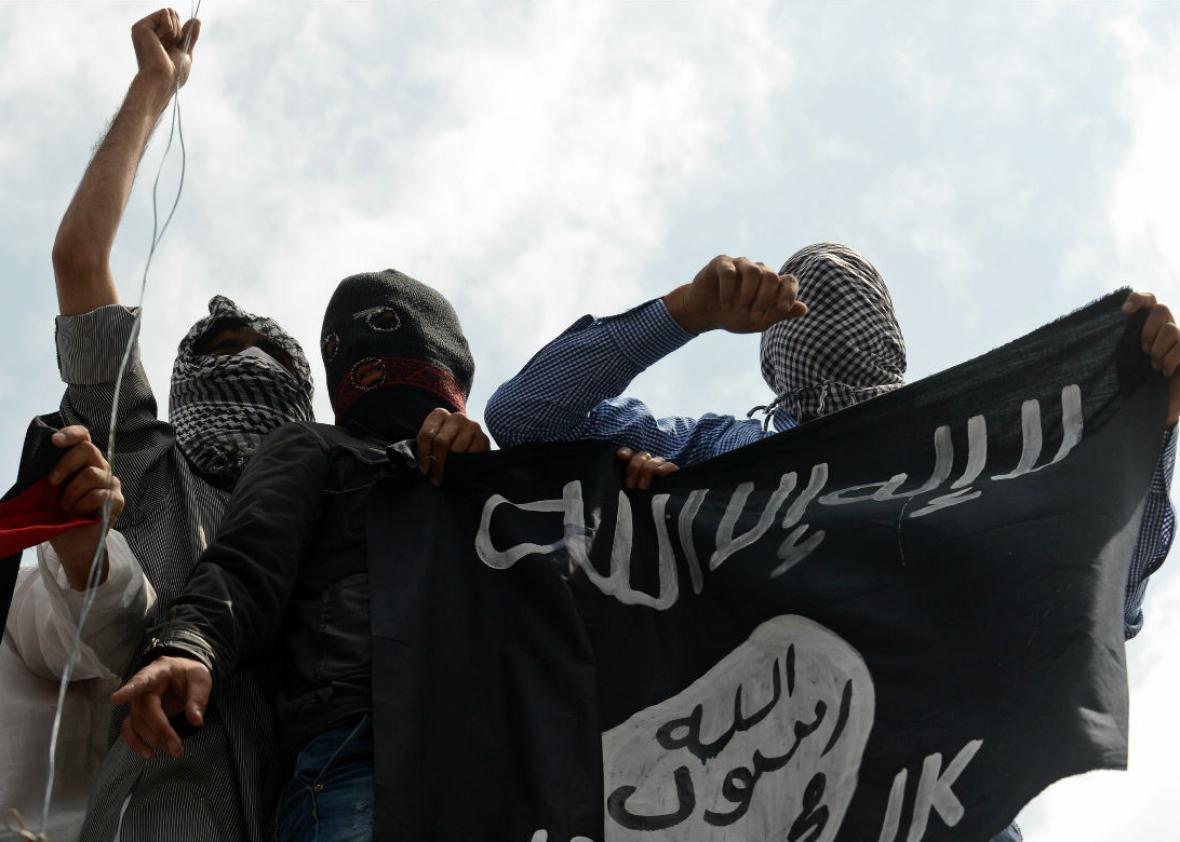 Kashmiri demonstrators hold up a ISIS flag