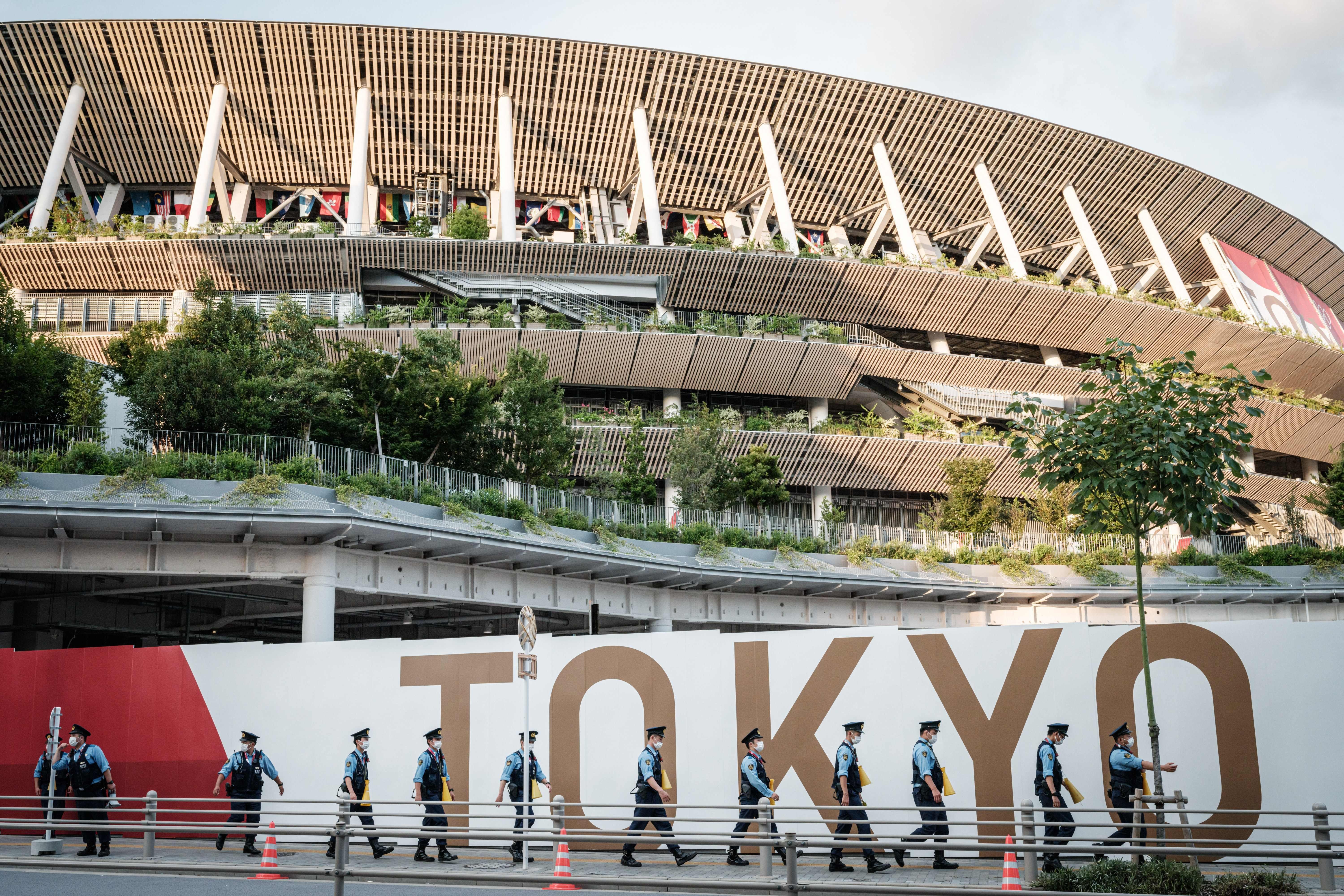 Police officers move towards their position ahead of the opening ceremony of the Tokyo 2020 Olympic Games near the Olympic Stadium in Tokyo on July 23, 2021. (Photo by Yasuyoshi CHIBA / AFP) (Photo by YASUYOSHI CHIBA/AFP via Getty Images)