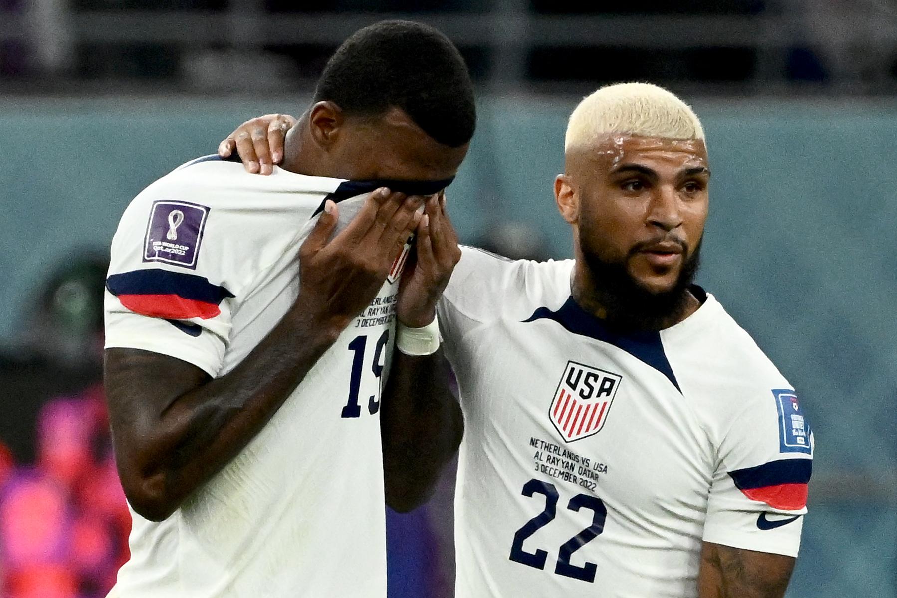 Wright wipes his face with his jersey and Yedlin wraps his arm around him