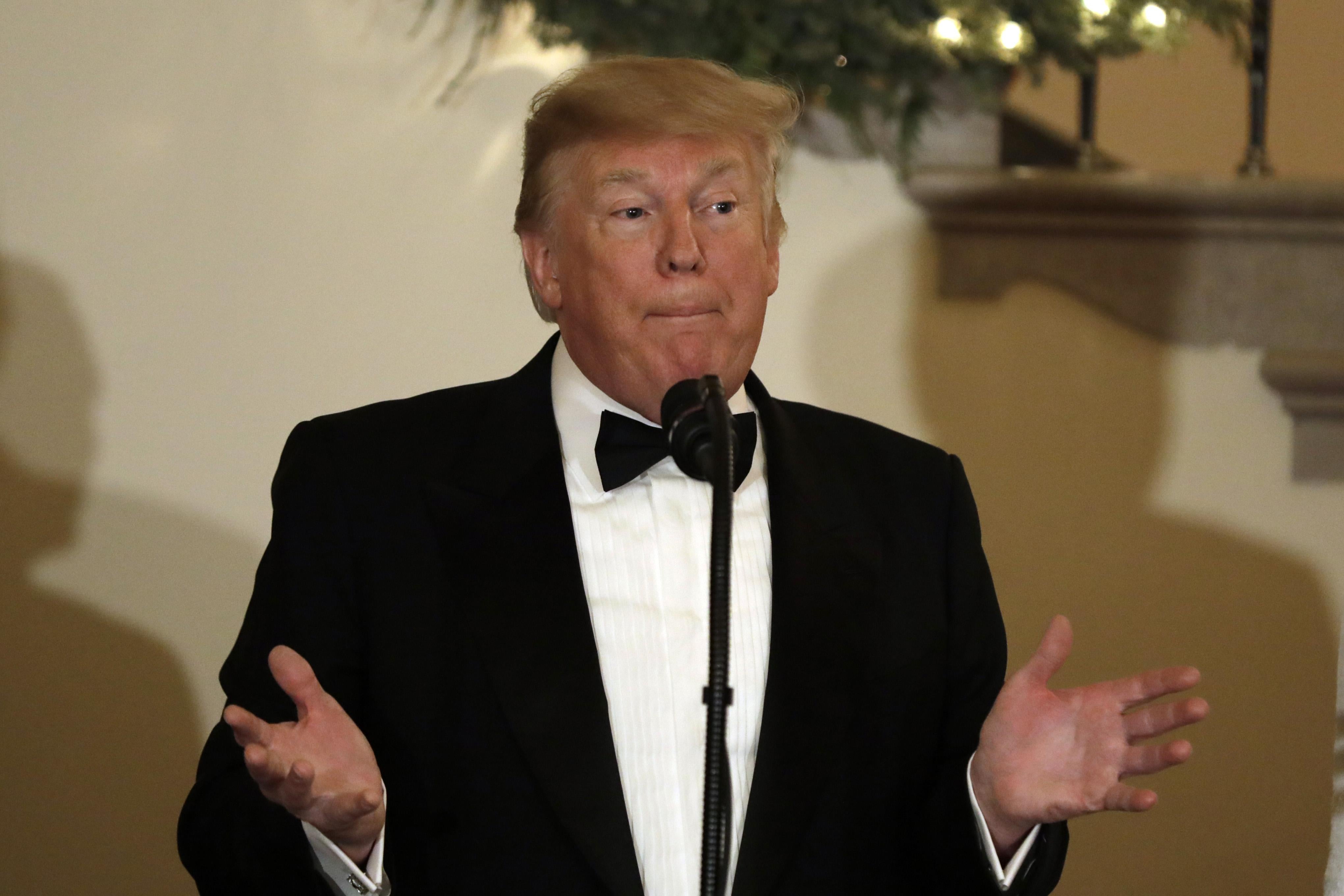 Trump in a tuxedo, speaking at a lectern 