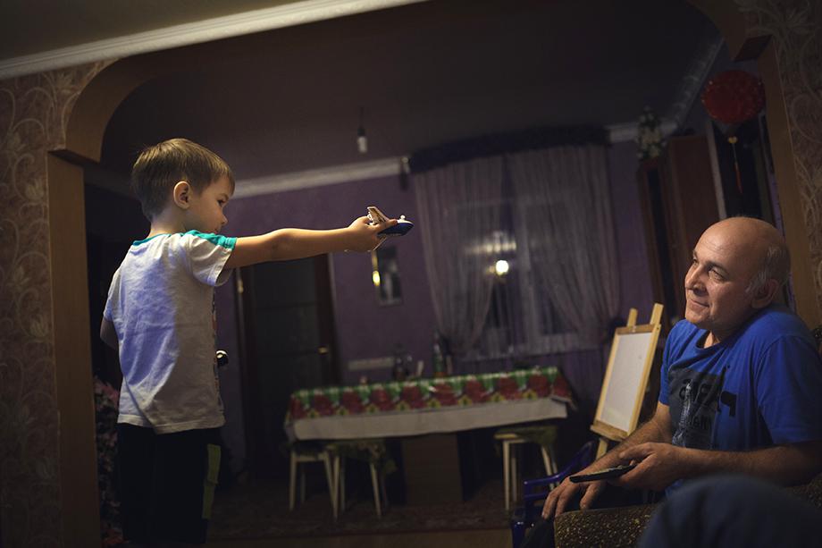 Danila plays with his planes at home with grandfather Aleksander Kovalenko.