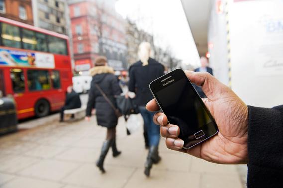 A man uses a Samsung Galaxy Ace smartphone on the streets of London, February 11, 2011.