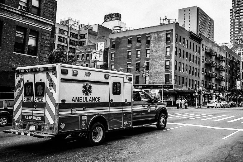 An ambulance stops at a stoplight.