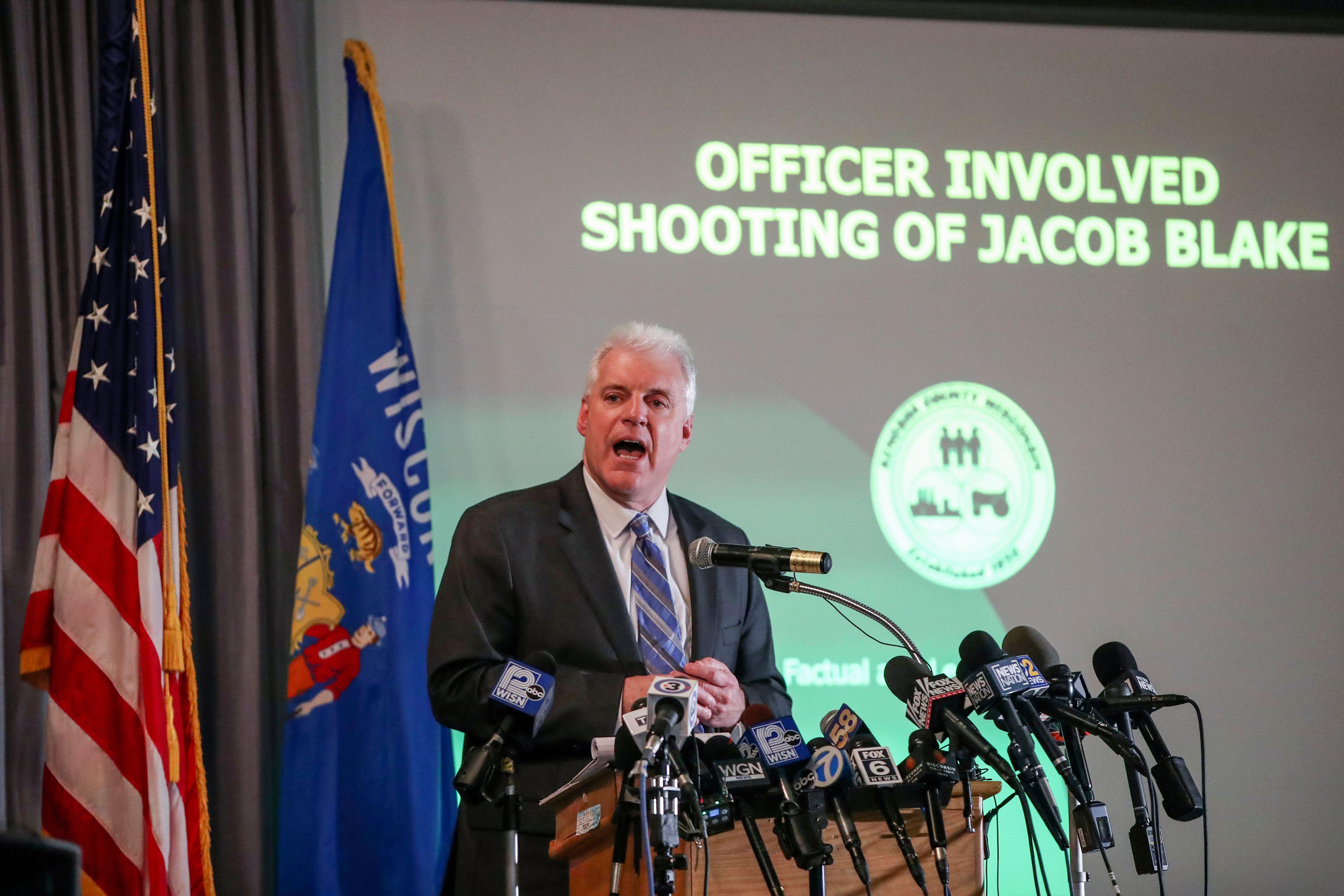 Kenosha District Attorney Michael Graveley speaks at a mic in front of a screen that reads "Officer Involved Shooting of Jacob Blake"