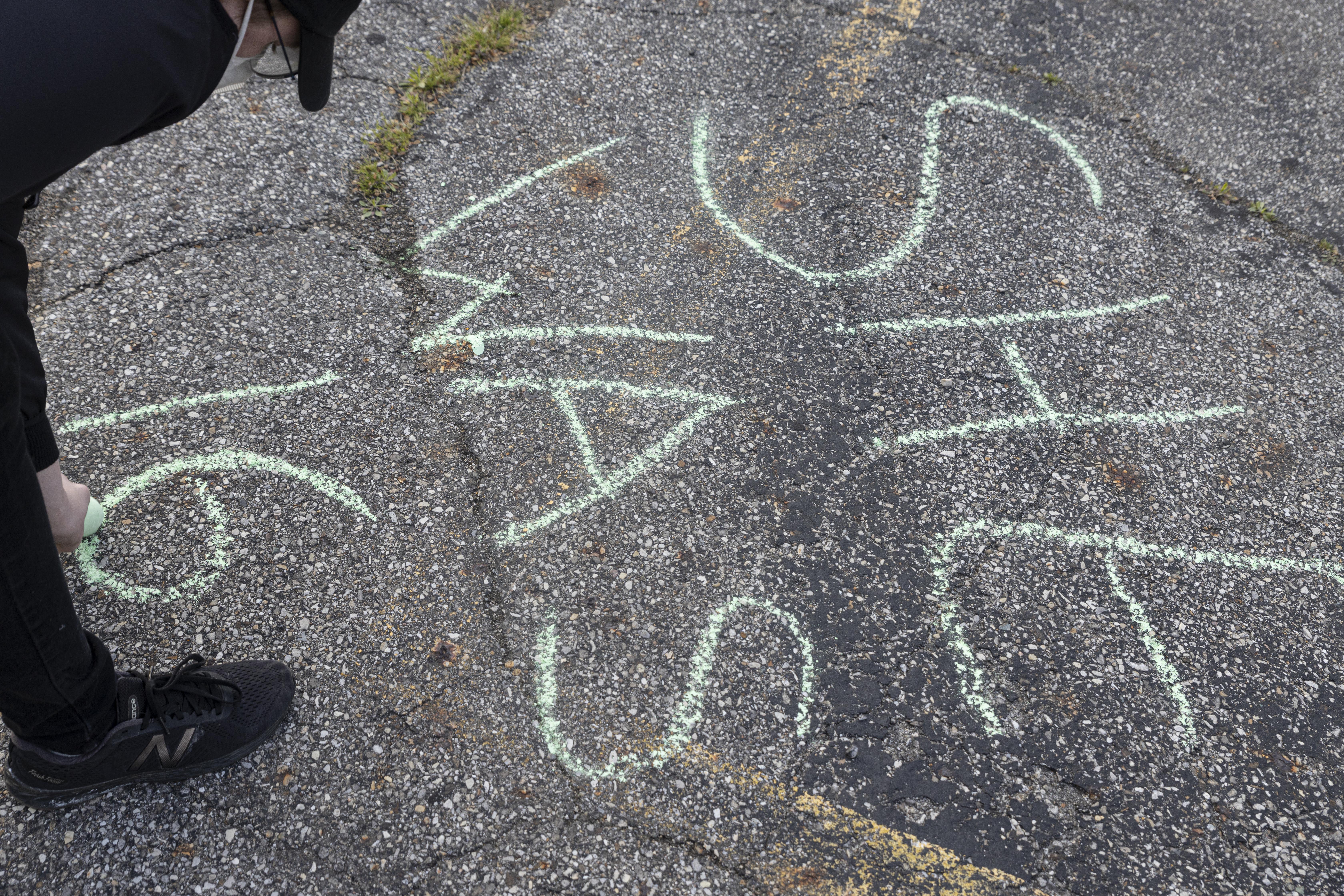 Woman writes in chalk during a vigil in honor of Ma'Khia on April 21, 2021 in Columbus, Ohio. 