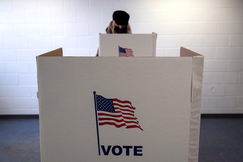 A voter in Lansing, Michigan fills out her ballot, wearing a mask.