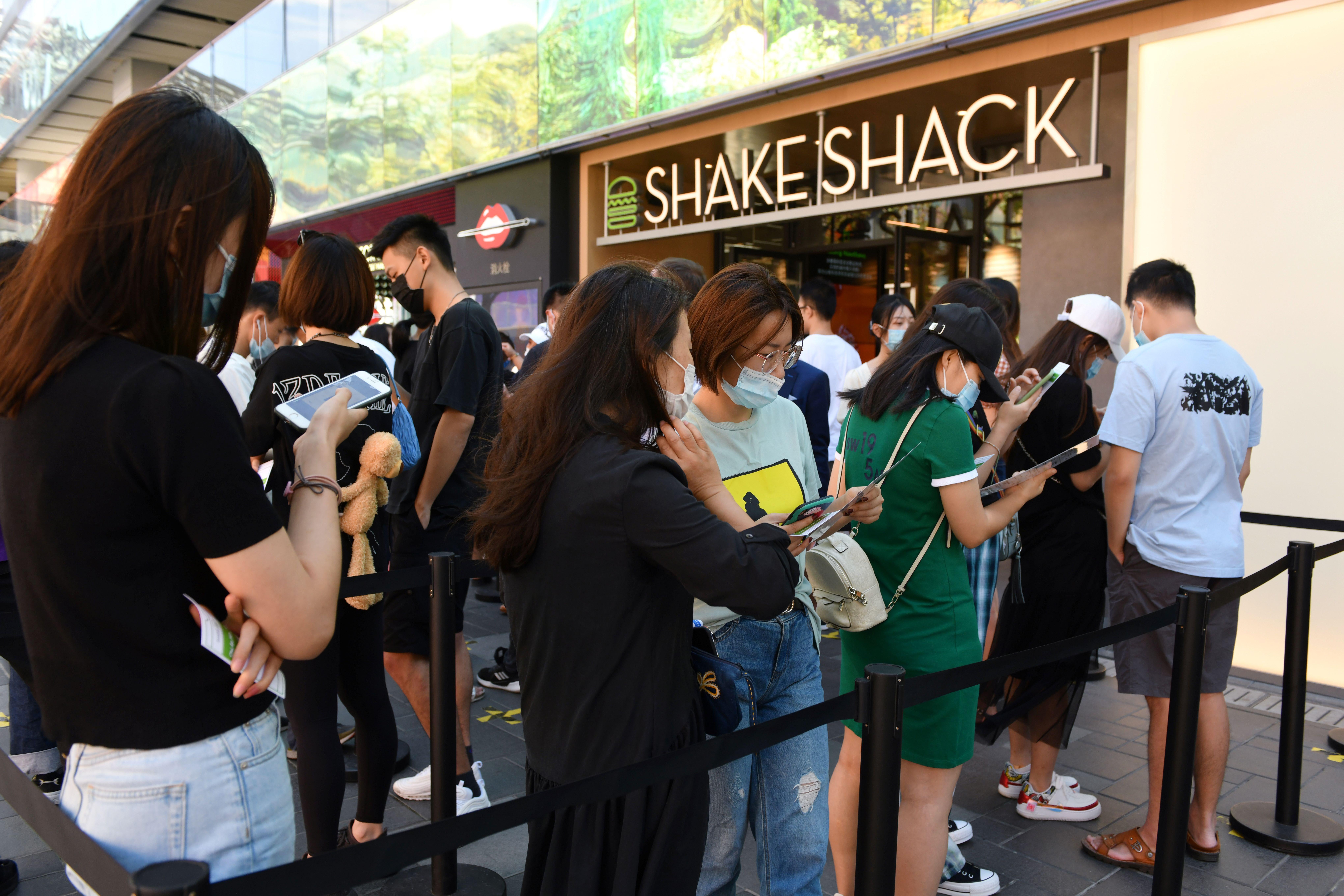 People wait in line to eat at a Shake Shack restaurant in Beijing. 