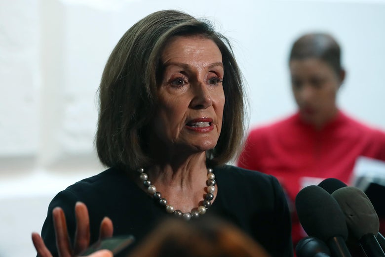 Nancy Pelosi speaks into microphones.