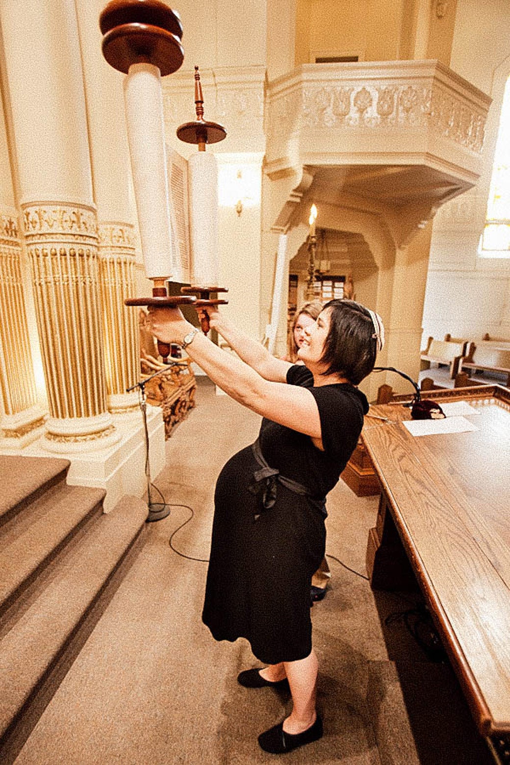 Jacqueline holds up two large scrolls.