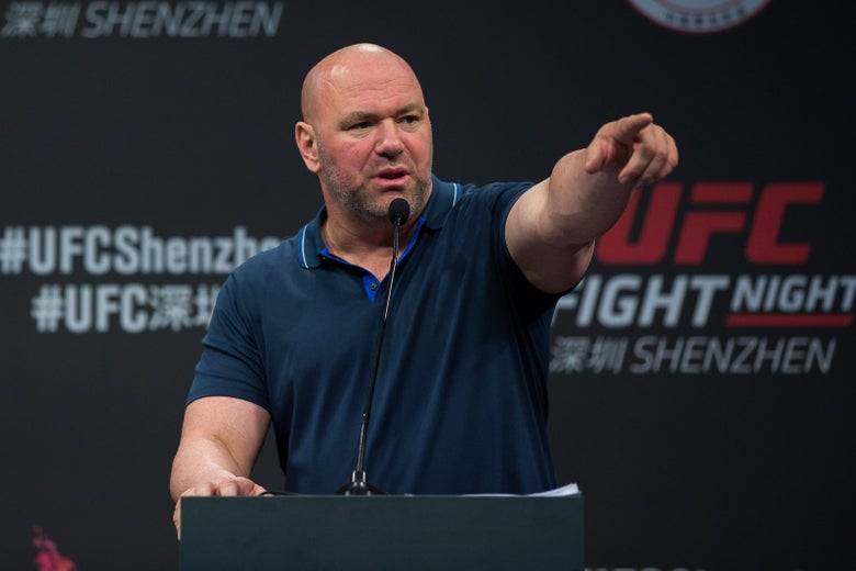 Dana White points while speaking at a podium during a press conference.