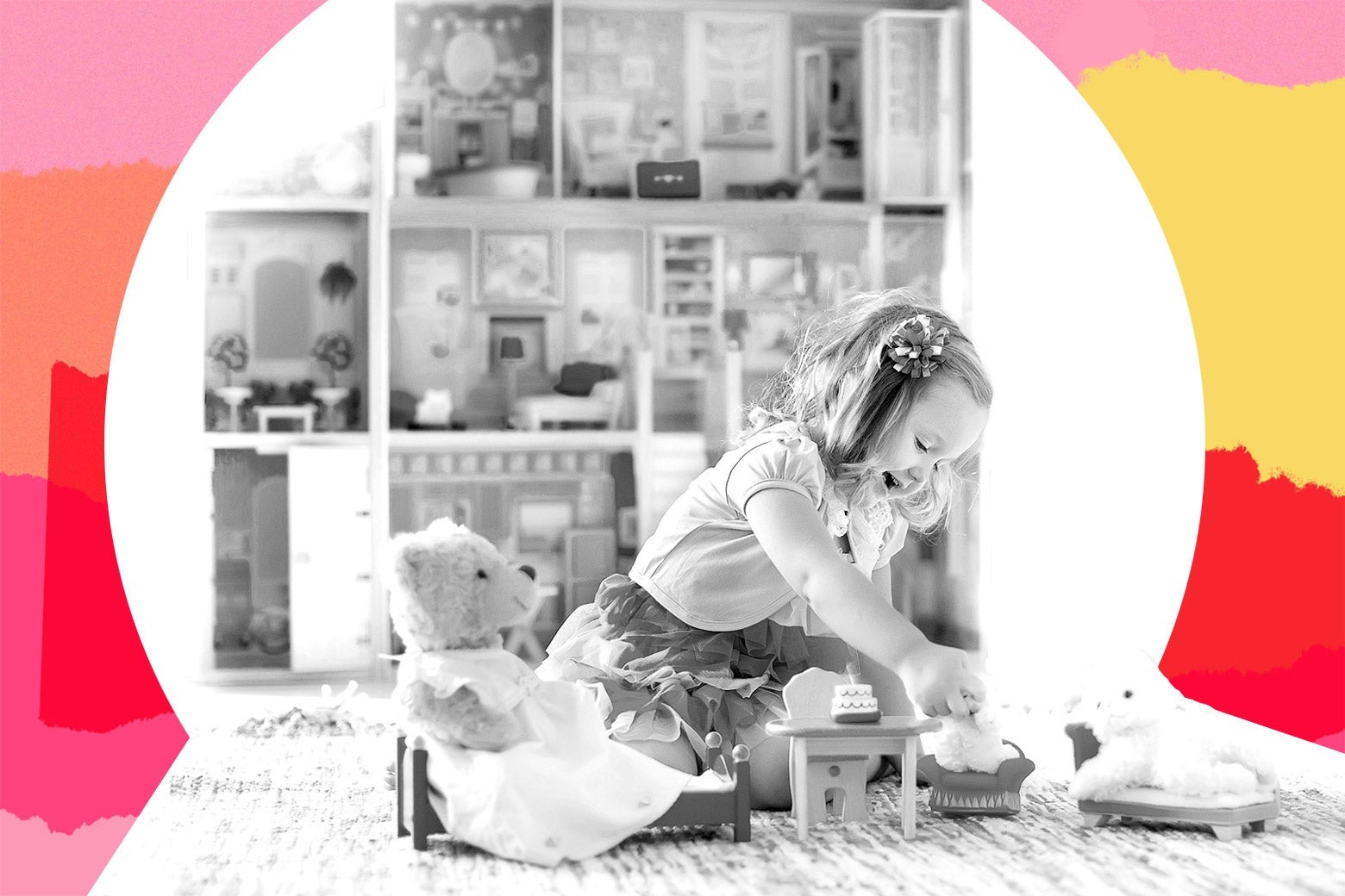 A little girl wearing a dress sits on the floor having tea with her toys in front of a large dollhouse