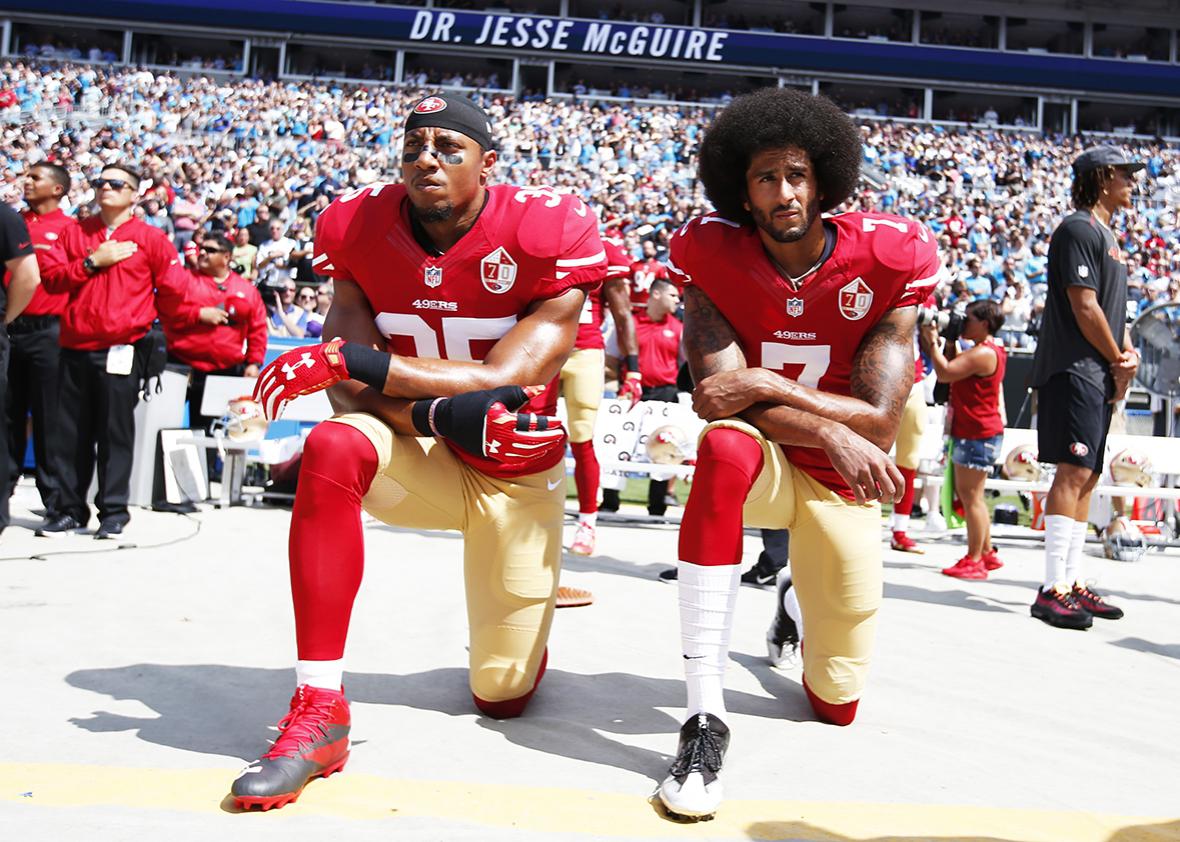 Eric Reid #35 and Colin Kaepernick #7 of the San Francisco 49ers kneel on the sideline, during the anthem, prior to the game against the Carolina Panthers at Bank of America Stadium on September 18, 2016 in Charlotte, North Carolina.