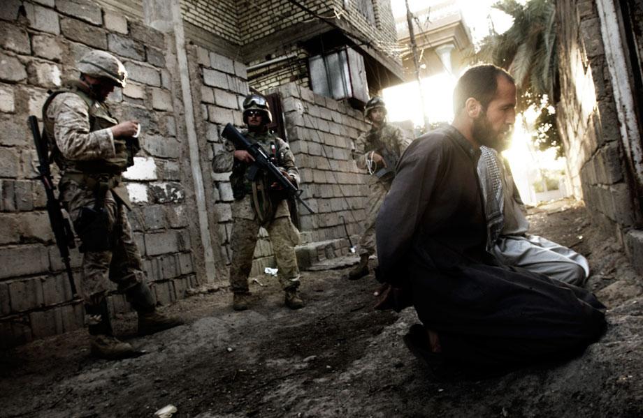 U.S. Marines of Weapons and Lima Company, 1st Marine Expeditionary Force (I MEF) arrest suspected insurgents during an all-out military offensive in Fallujah, Al Anbar governorate, Iraq on Nov. 12, 2004. Located some 40 miles west of the Iraqi capital, Fallujah has been the epicenter of a resistance that has dogged U.S. and Iraqi forces for over a year. On the eve of November 8th, in an attempt to recapture the city, Operation Phantom Fury commenced and coalition troops pushed into the area from the west and south. Soon, combat engulfed the forces' advance, as insurgents engaged them with sniper fire and RPGs in one of the fiercest battles yet.