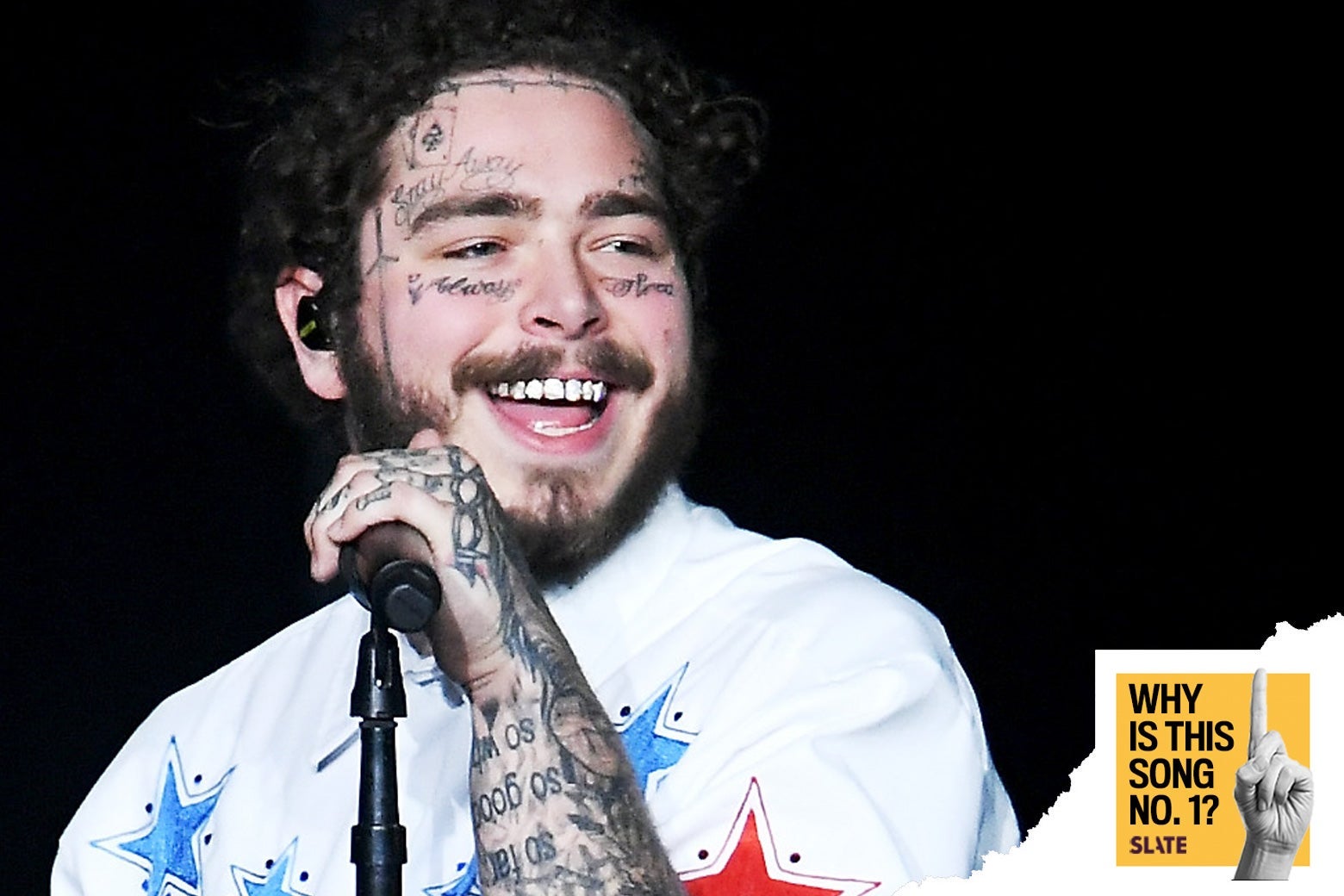 Post Malone holds a microphone while onstage.