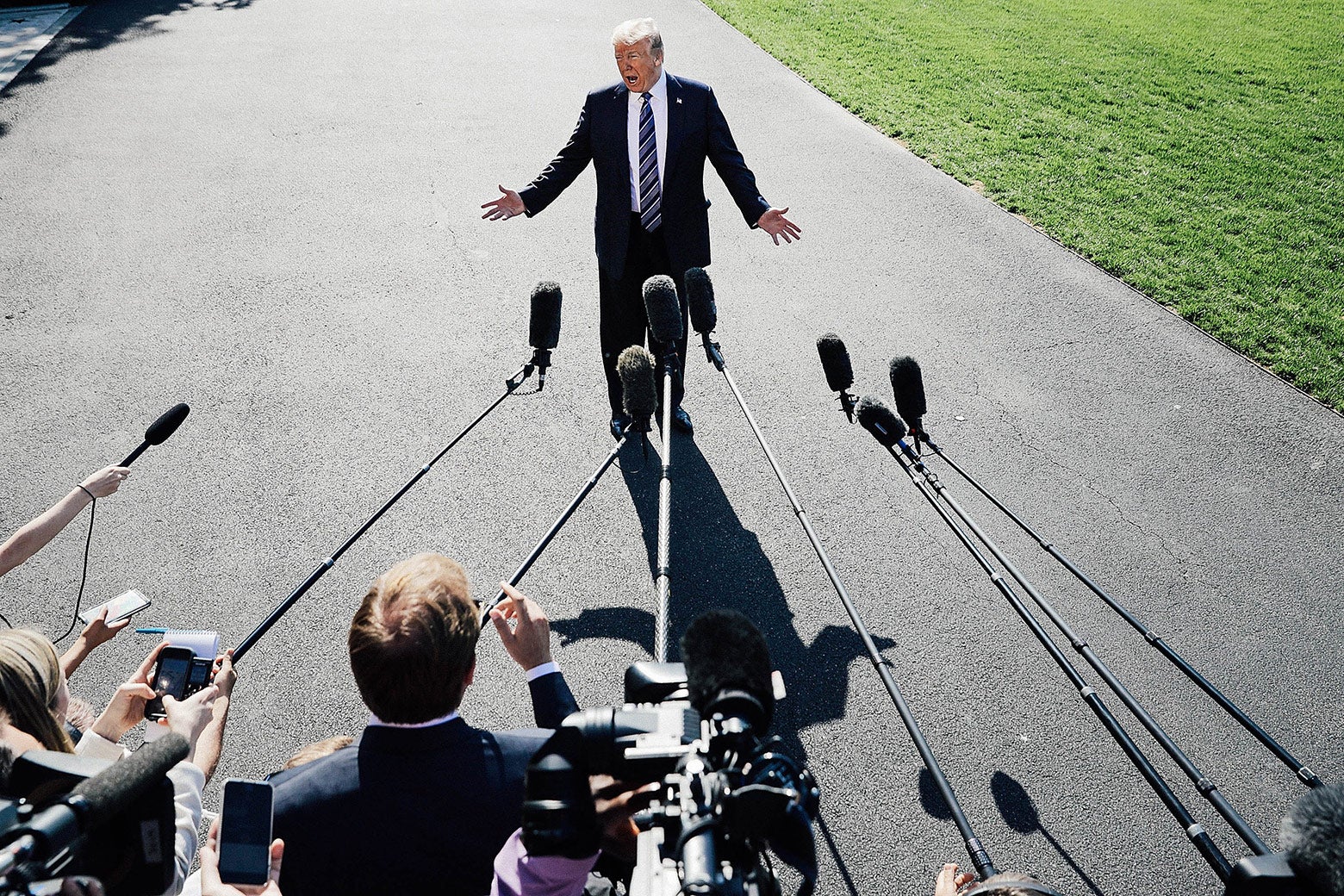President Donald Trump talks to members of the media before departing the White House on Friday in Washington.