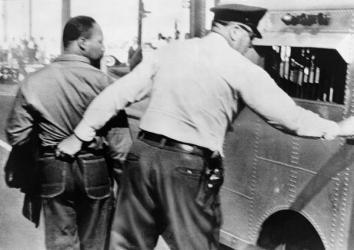 Police officer seizing Dr. Martin Luther King by his pants and leading him to a paddy wagon, after an anti-segregation march in Birmingham, Ala., 1963.