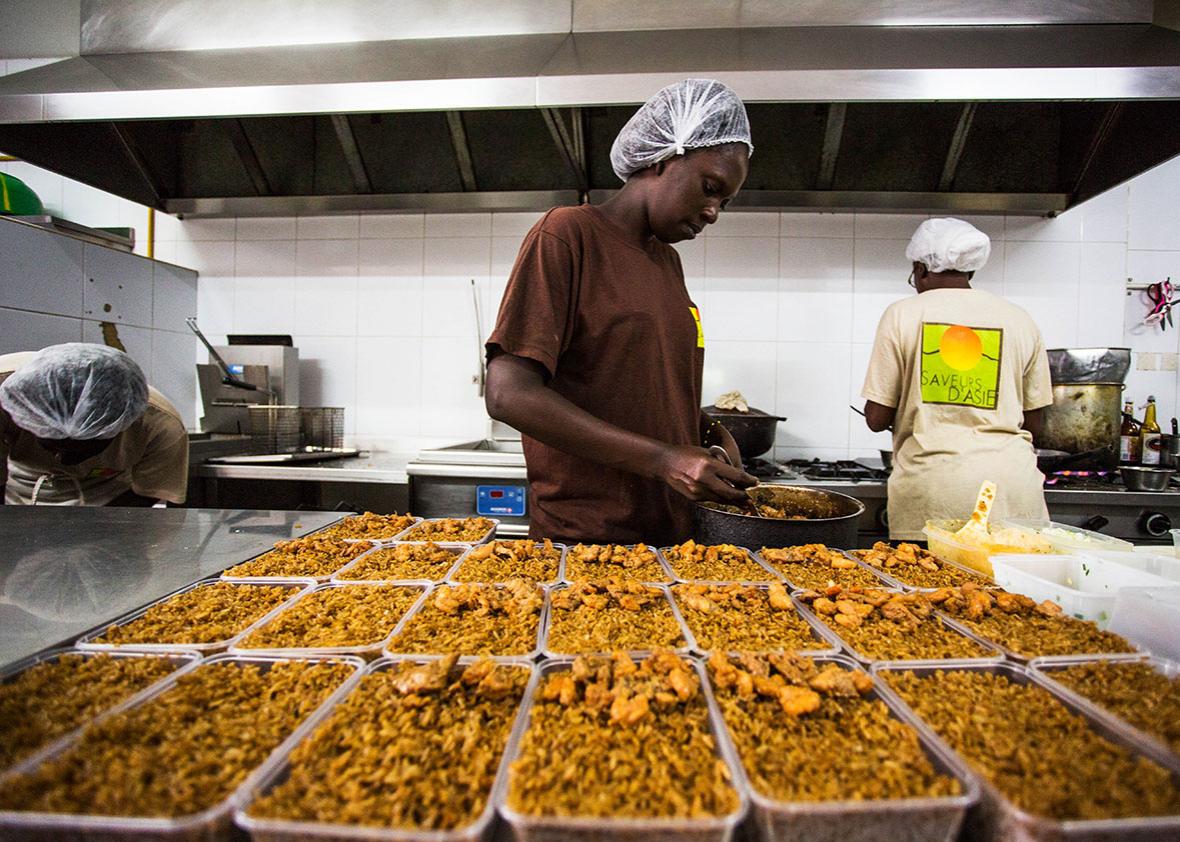 A server scoops fried rice at Saveurs d'Asie, a takeout chain in Senegal run by the son of a Vietnamese immigrant.