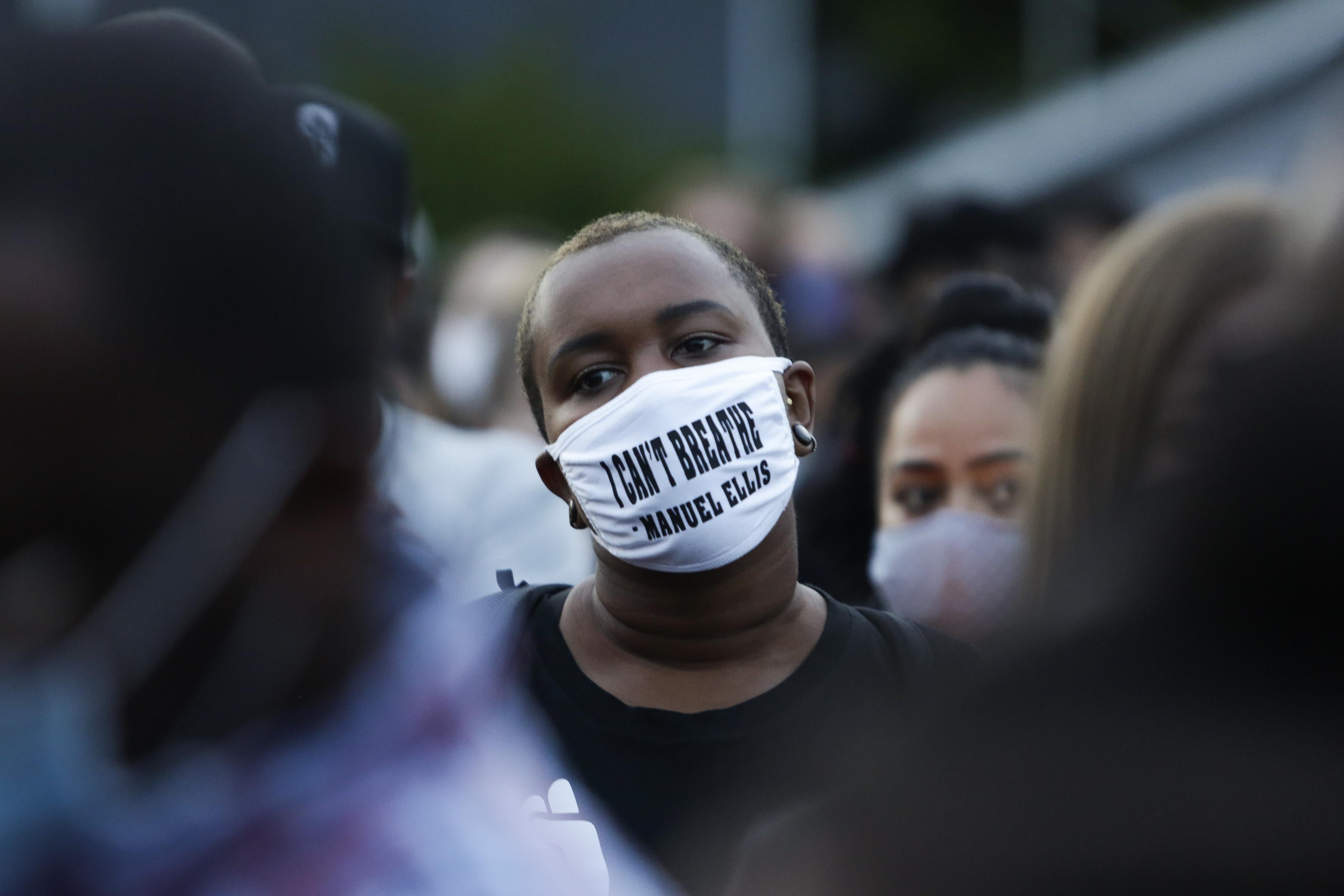 A man in a crowd wears a mask that says "I can't breathe."