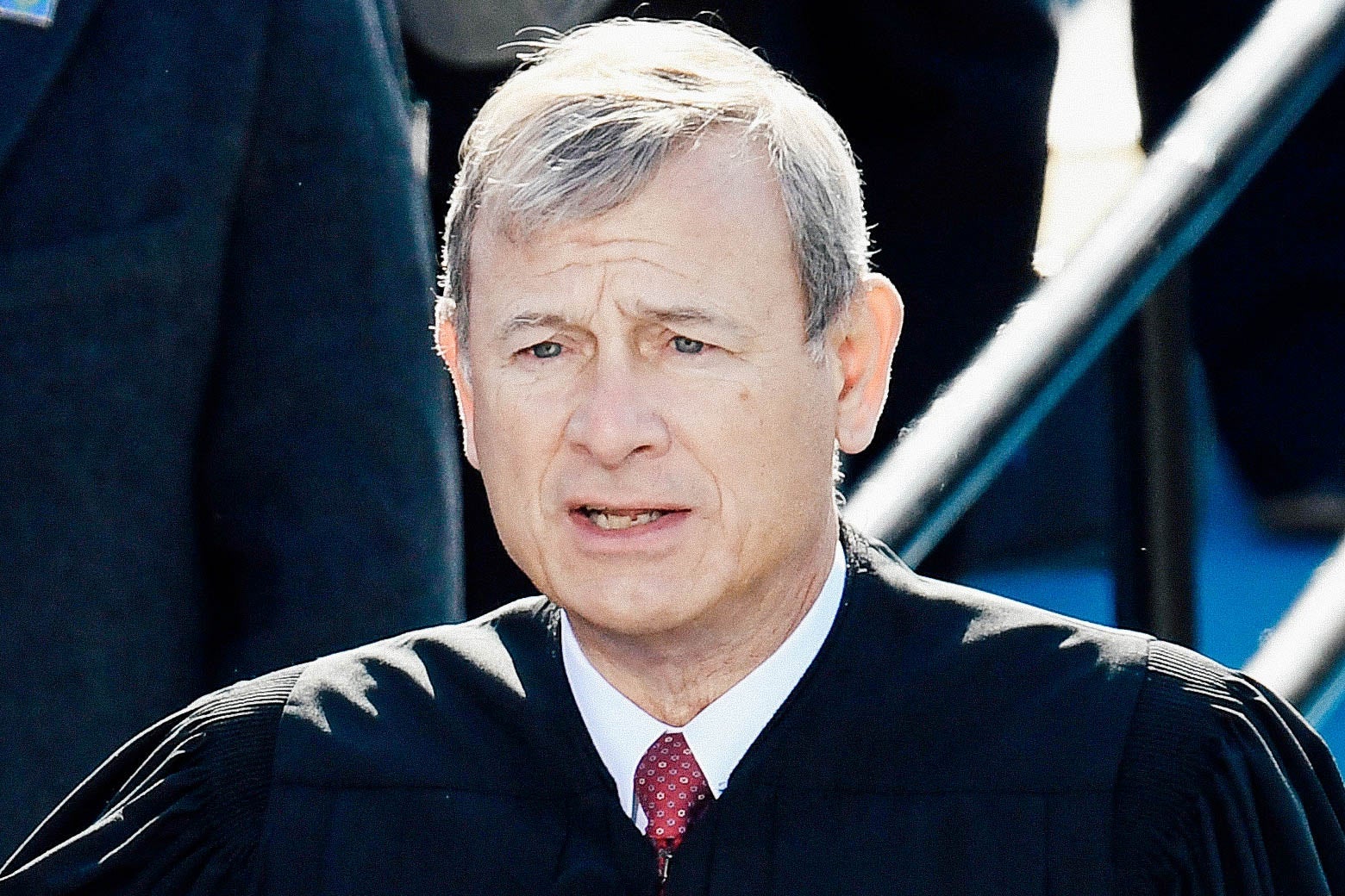 Chief Justice John Roberts stands outside in his robes as he administers the oath of office to Biden