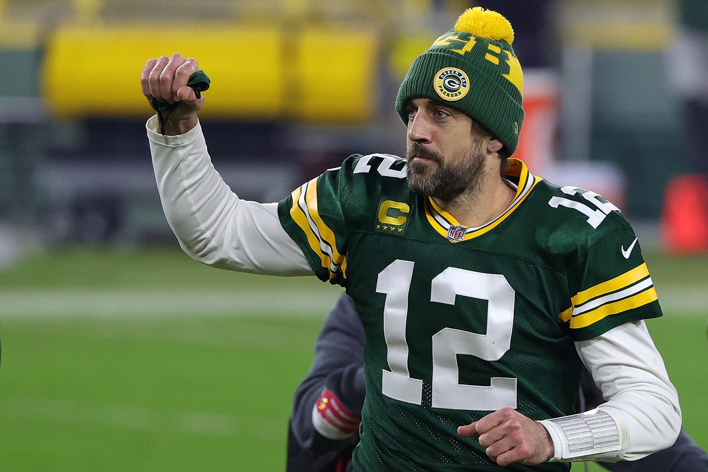 Aaron Rodgers puts his fist in the air as he leaves the field following the Packers' playoff game against the Los Angeles Rams at Lambeau Field on Jan. 16 in Green Bay, Wisconsin.