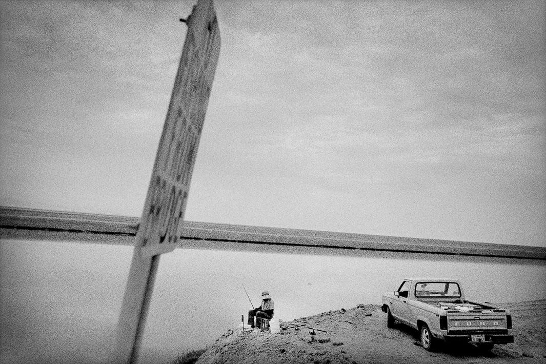 Fishing in an irrigation canal, Corcoran, California.