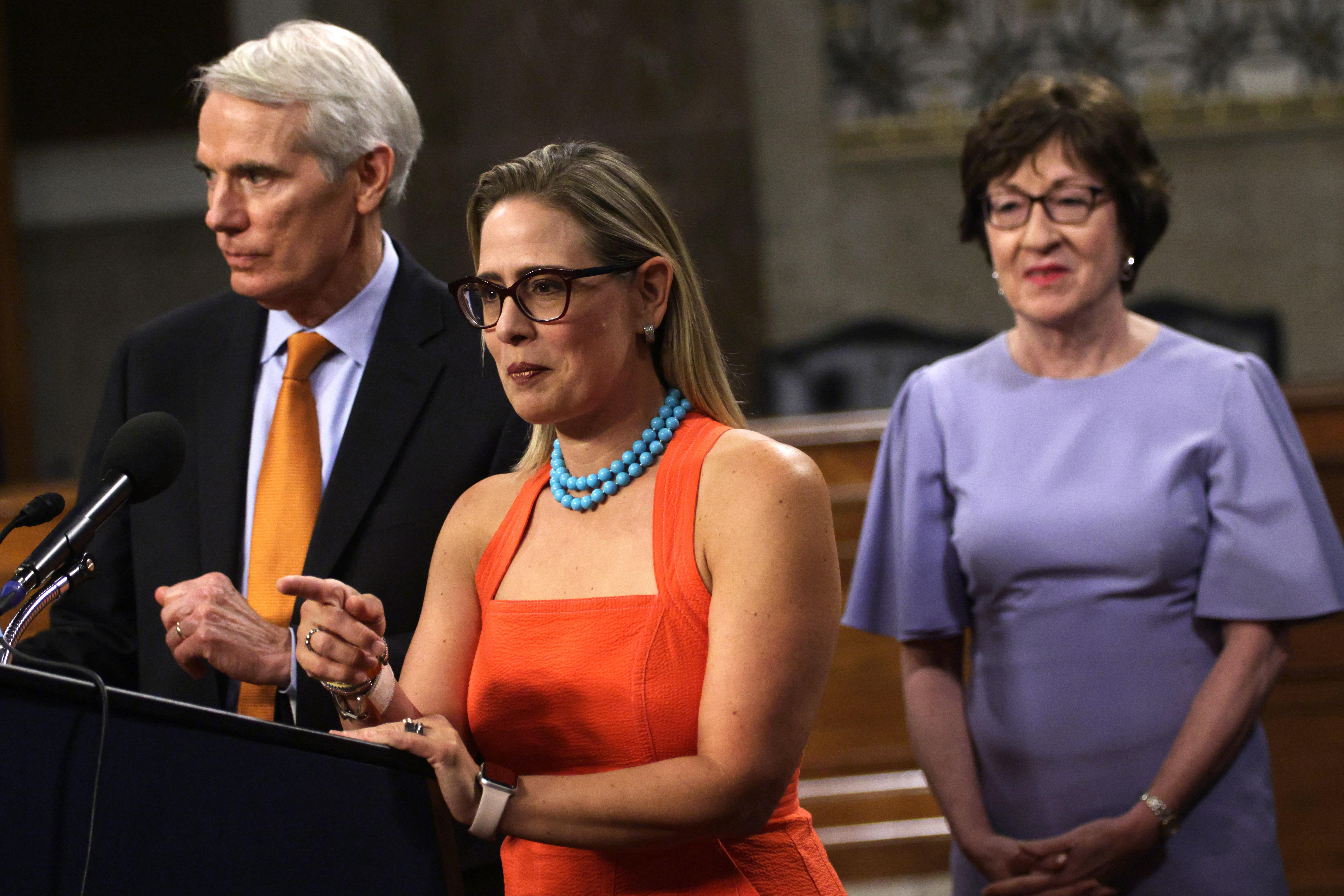 WASHINGTON, DC - JULY 28:  U.S. Sen. Rob Portman (R-OH) (L) and Sen. Kyrsten Sinema (D-AZ) (2nd L) answer questions from members of the press as Sen. Susan Collins (R-ME) looks on during a news conference after a procedural vote for the bipartisan infrastructure framework at Dirksen Senate Office Building July 28, 2021 on Capitol Hill in Washington, DC. The Senate has advanced the bipartisan infrastructure framework with the vote of 67-32. (Photo by Alex Wong/Getty Images)