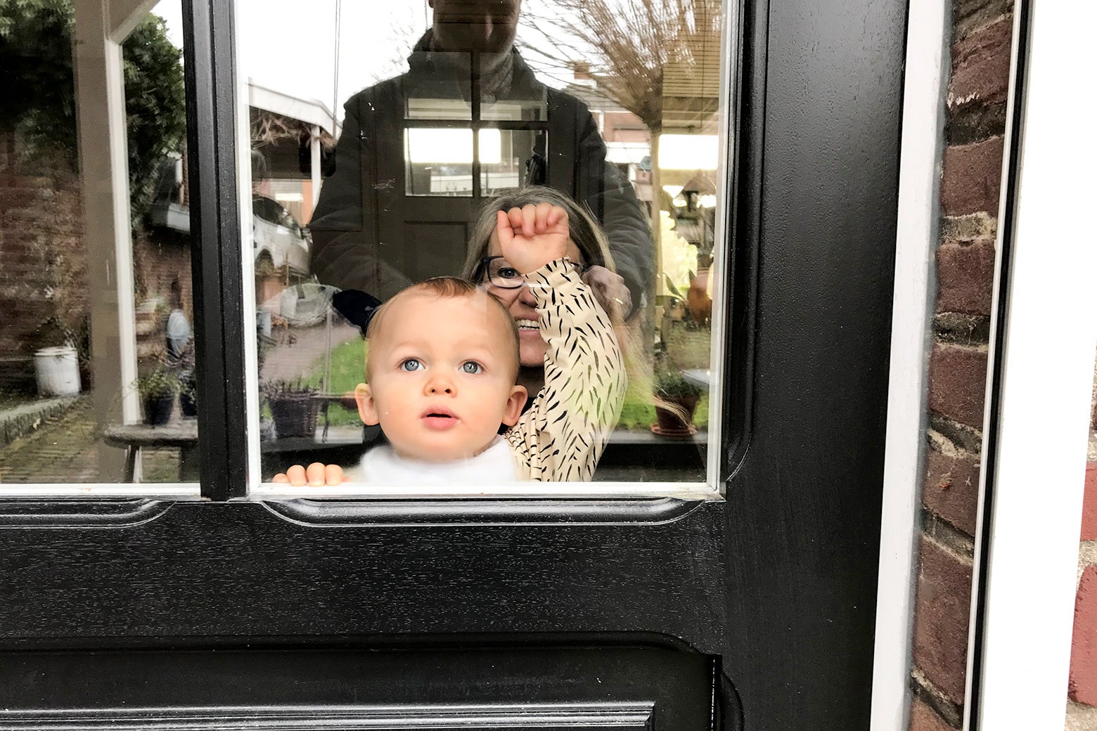 A baby tapping at a door window