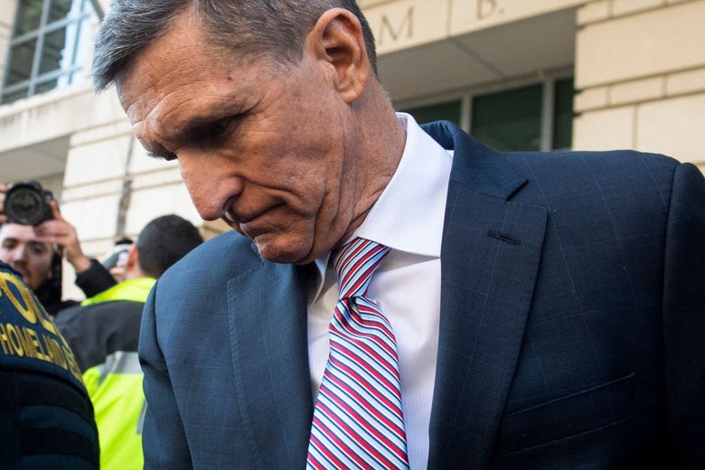 Flynn, wearing a suit, looks downward.