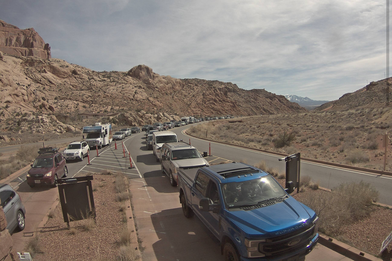 A long line of cars waits to get in to Arches National Park.