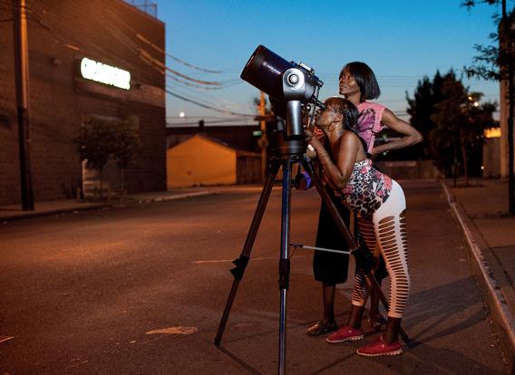 two women observe Saturn