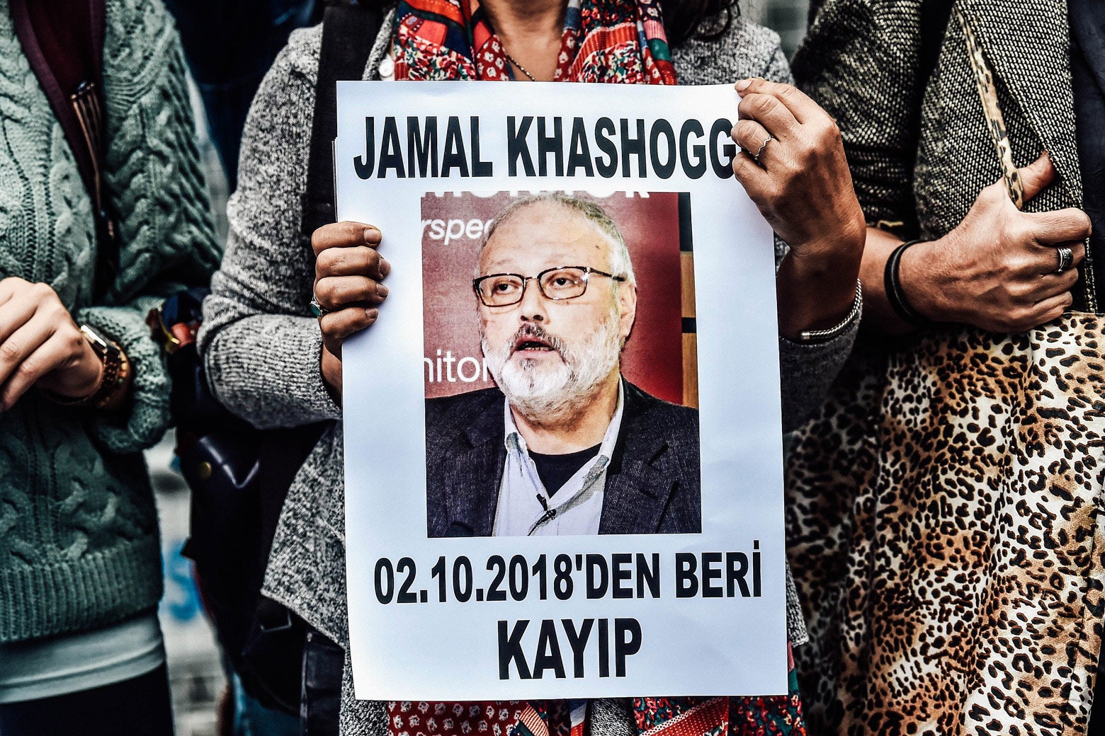 A woman holds a portrait of missing journalist Jamal Khashoggi reading "Jamal Khashoggi is missing since October 2."