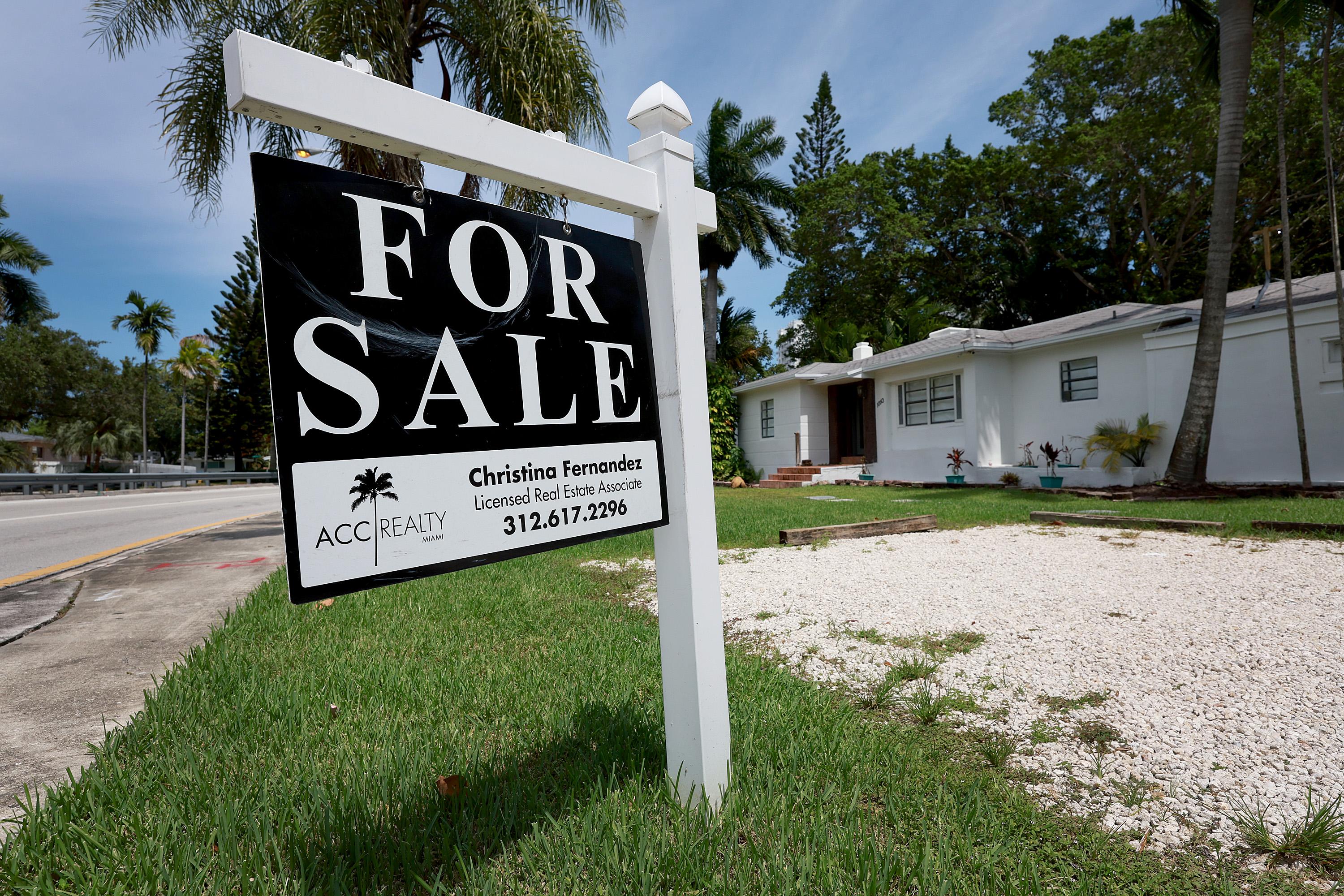 MIAMI, FLORIDA - JUNE 21: A 'for sale' sign hangs in front of a home on June 21, 2022 in Miami, Florida. 