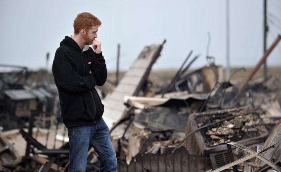 Gavin Byrne views damage in the Breezy Point area of Queens in New York on October 30, 2012 after fire destroyed about 80 homes as a result of Hurricane Sandy.