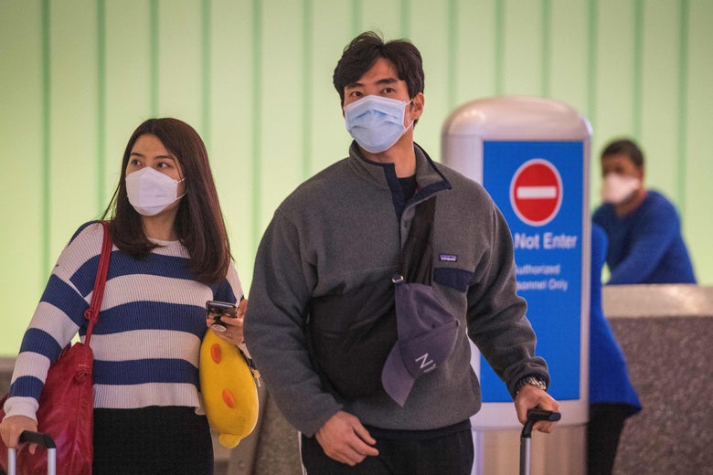 Passengers wear face masks to protect against the spread of the coronavirus as they arrive at LAX airport in Los Angeles, California on February 29, 2020. 
