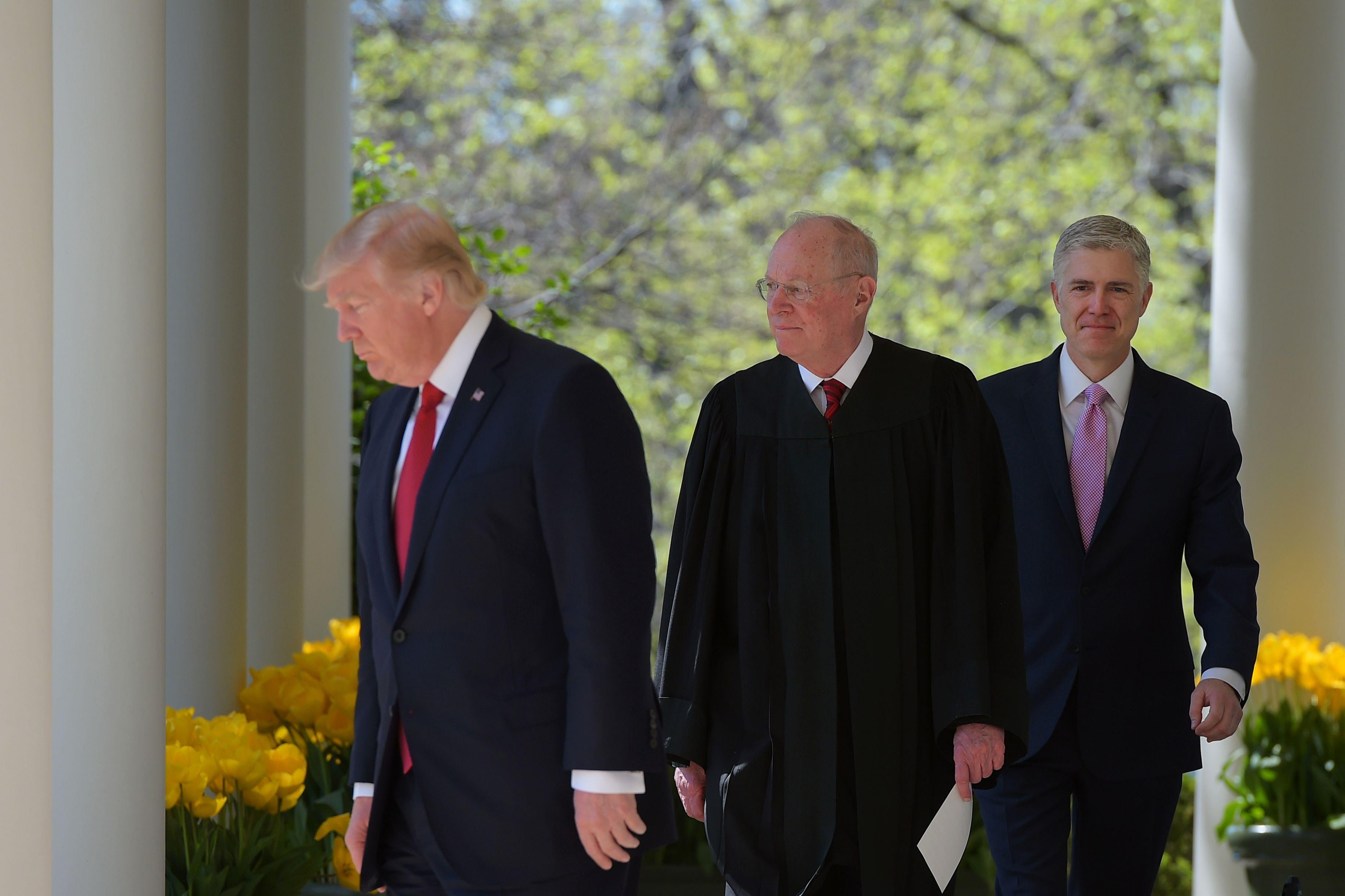President Donald Trump, Justice Anthony Kennedy and Neil Gorsuch make their way to the Rose Garden of the White House for Gorsuch's swearing-in ceremony  on April 10, 2017.
