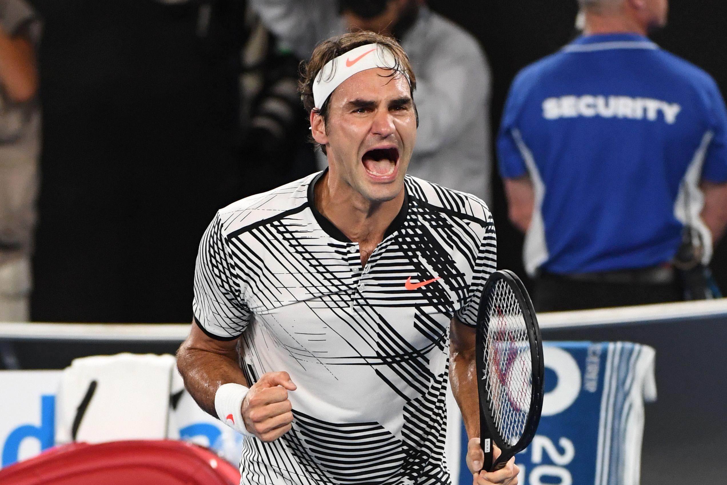 Fed pumps his fist and screams on court, racquet clutched in his left hand.