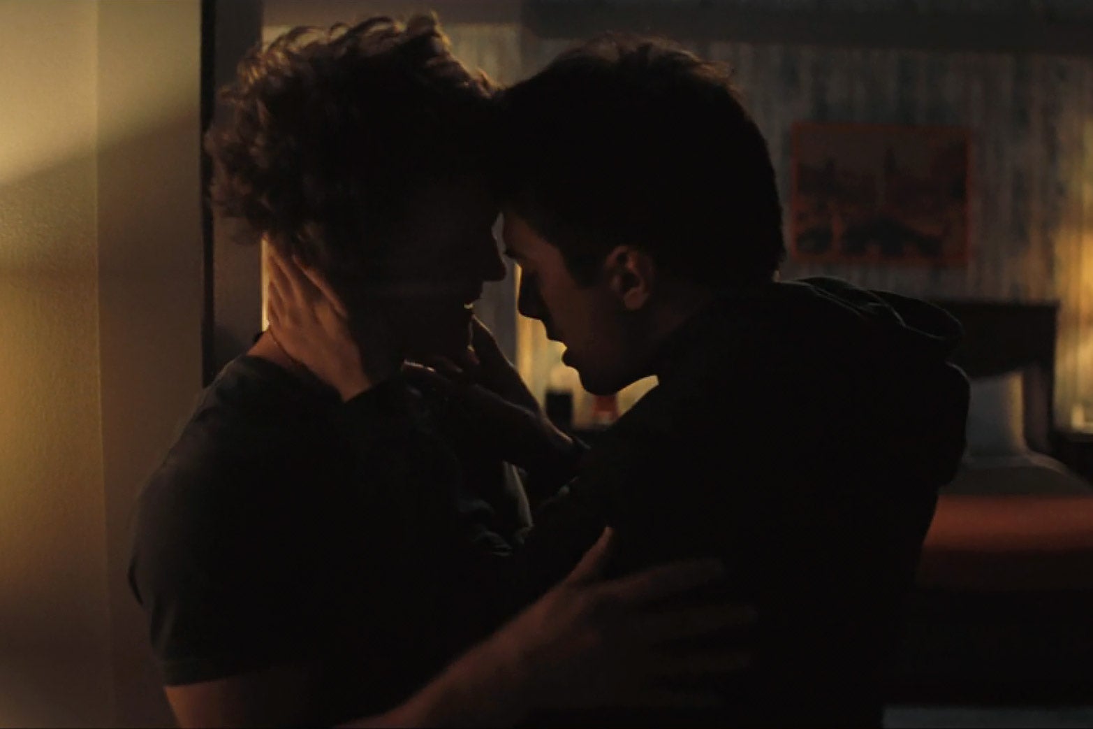Two men embracing each other in a hotel room.