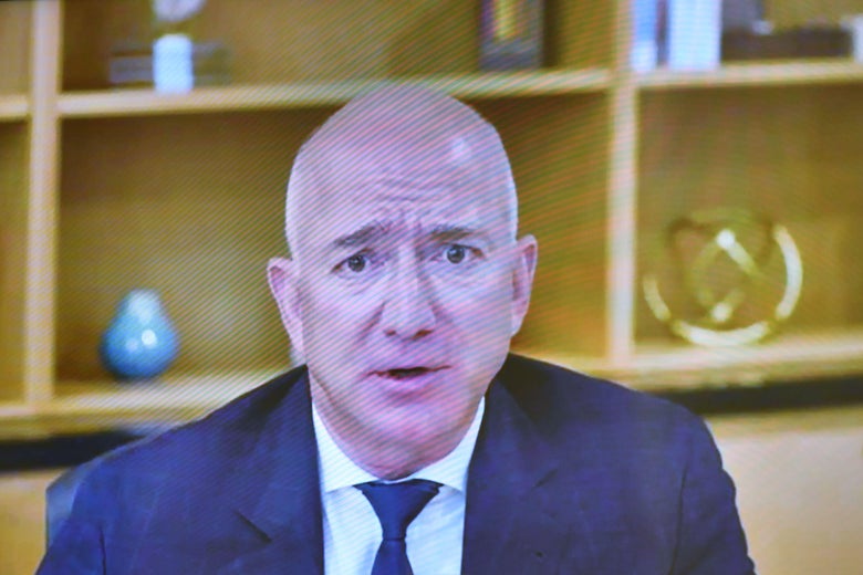 A man in a suit with eyebrows frowned as if worried or thinking hard.