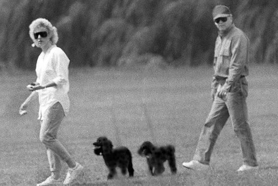 Whitey Bulger and Catherine Greig walk together with Greig's poodles underfoot, June 1988.