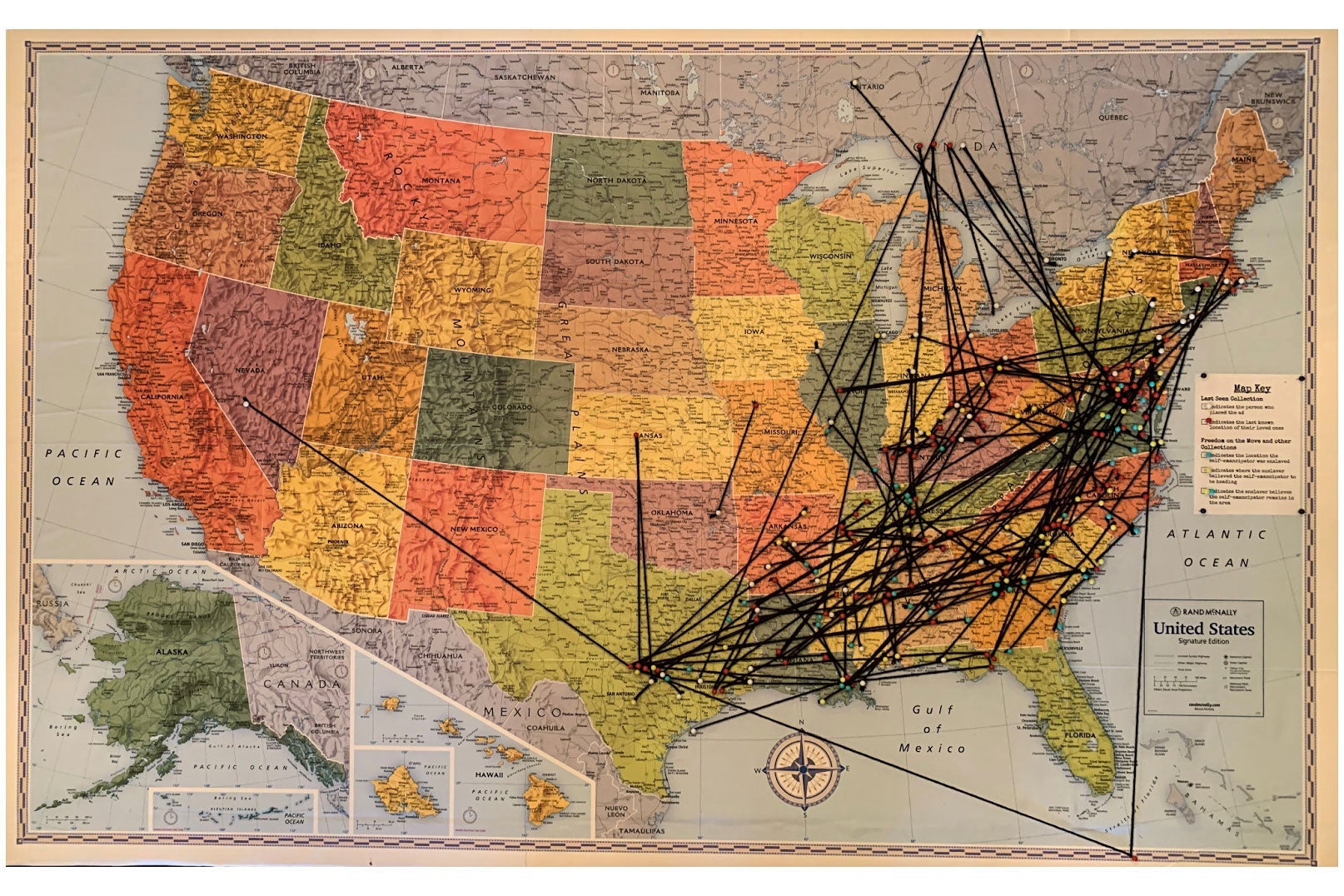 A classroom map of the U.S. with lines of black string all over it showing the paths of enslaved people to freedom