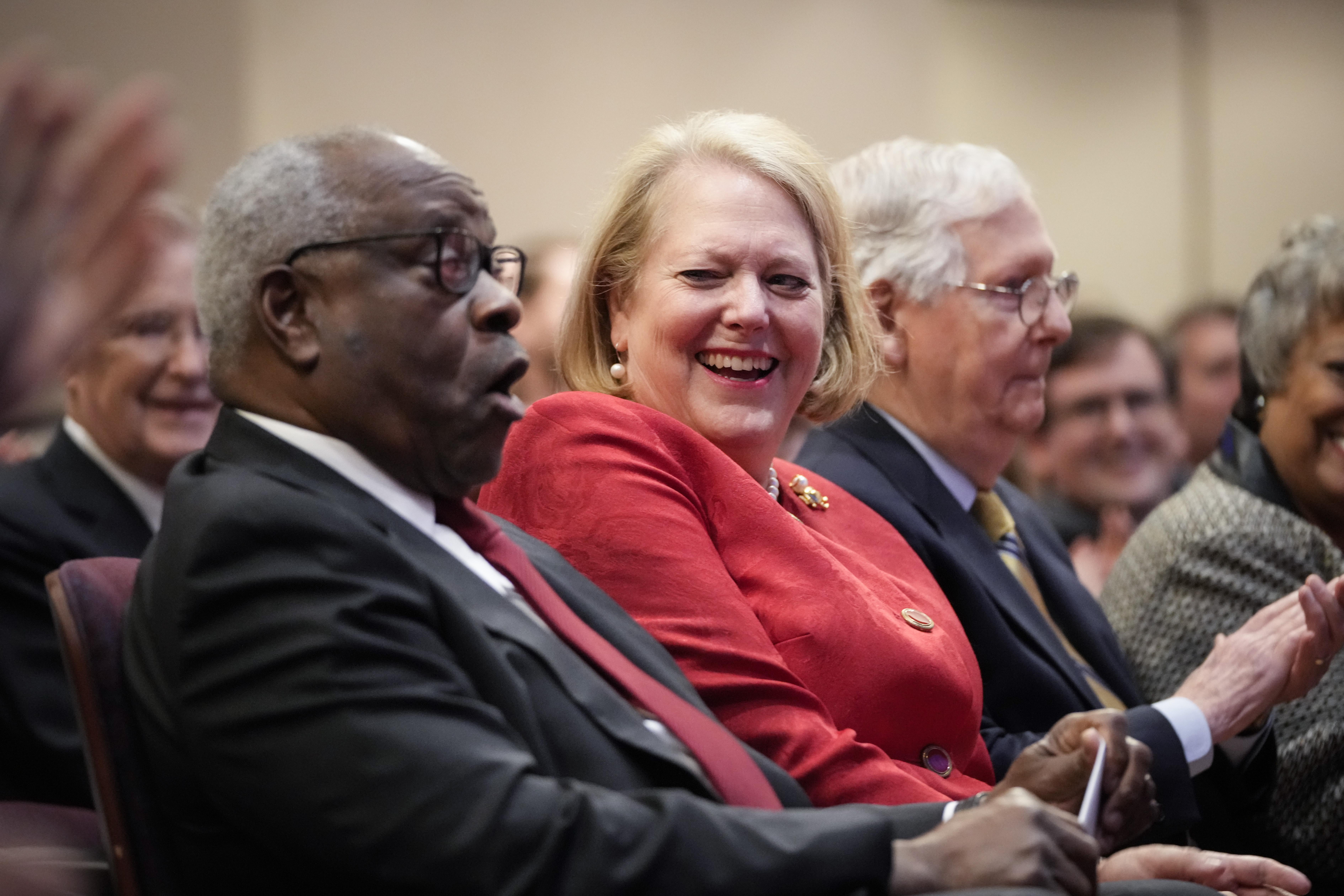 Clarence and Ginni Thomas share a laugh while seated next to Mitch McConnell.