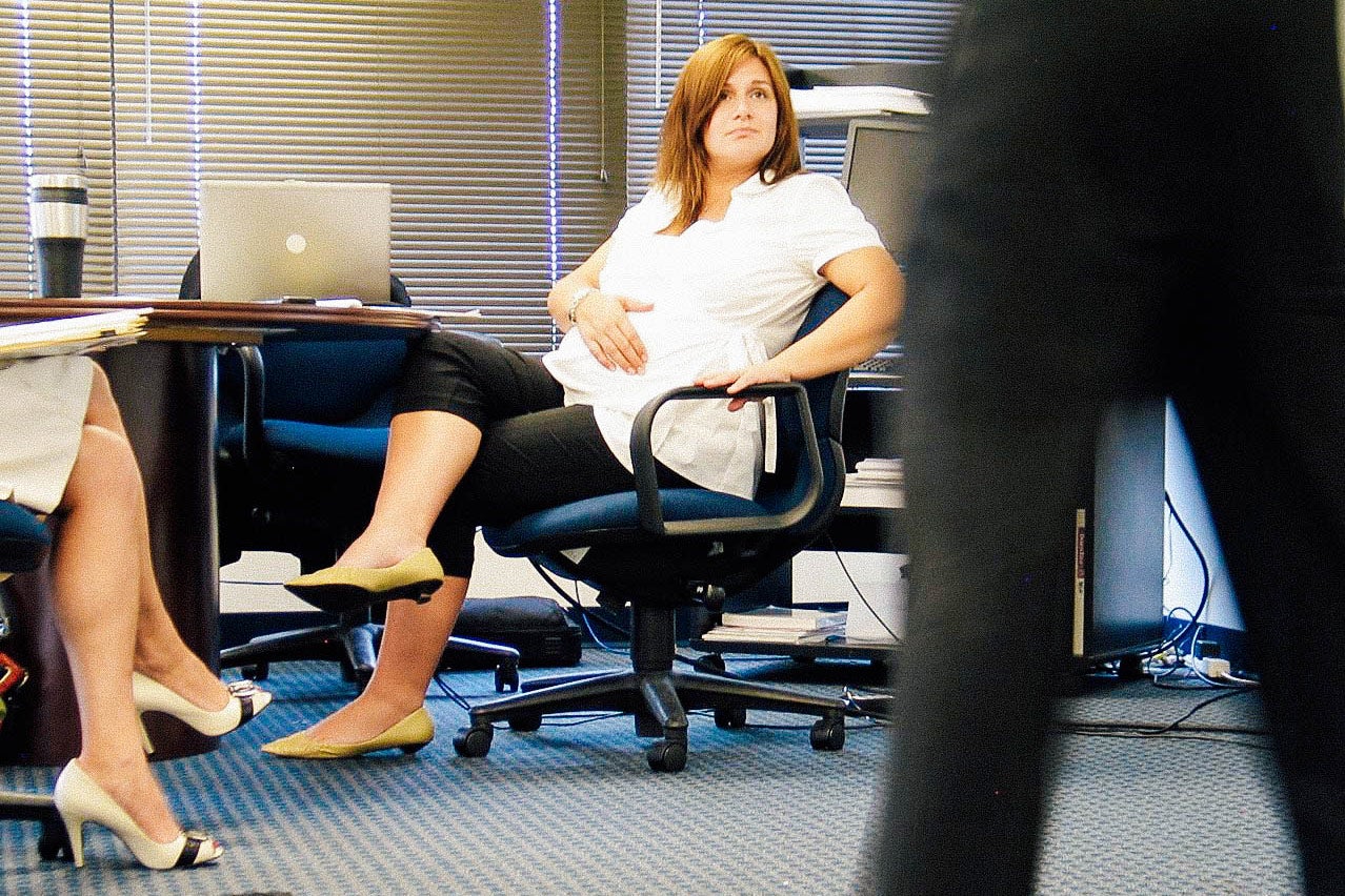 Christine sits in a meeting in an office.