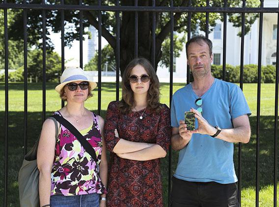 A Swedish family pose in front of the White House while Dad photographs me on his iPhone.