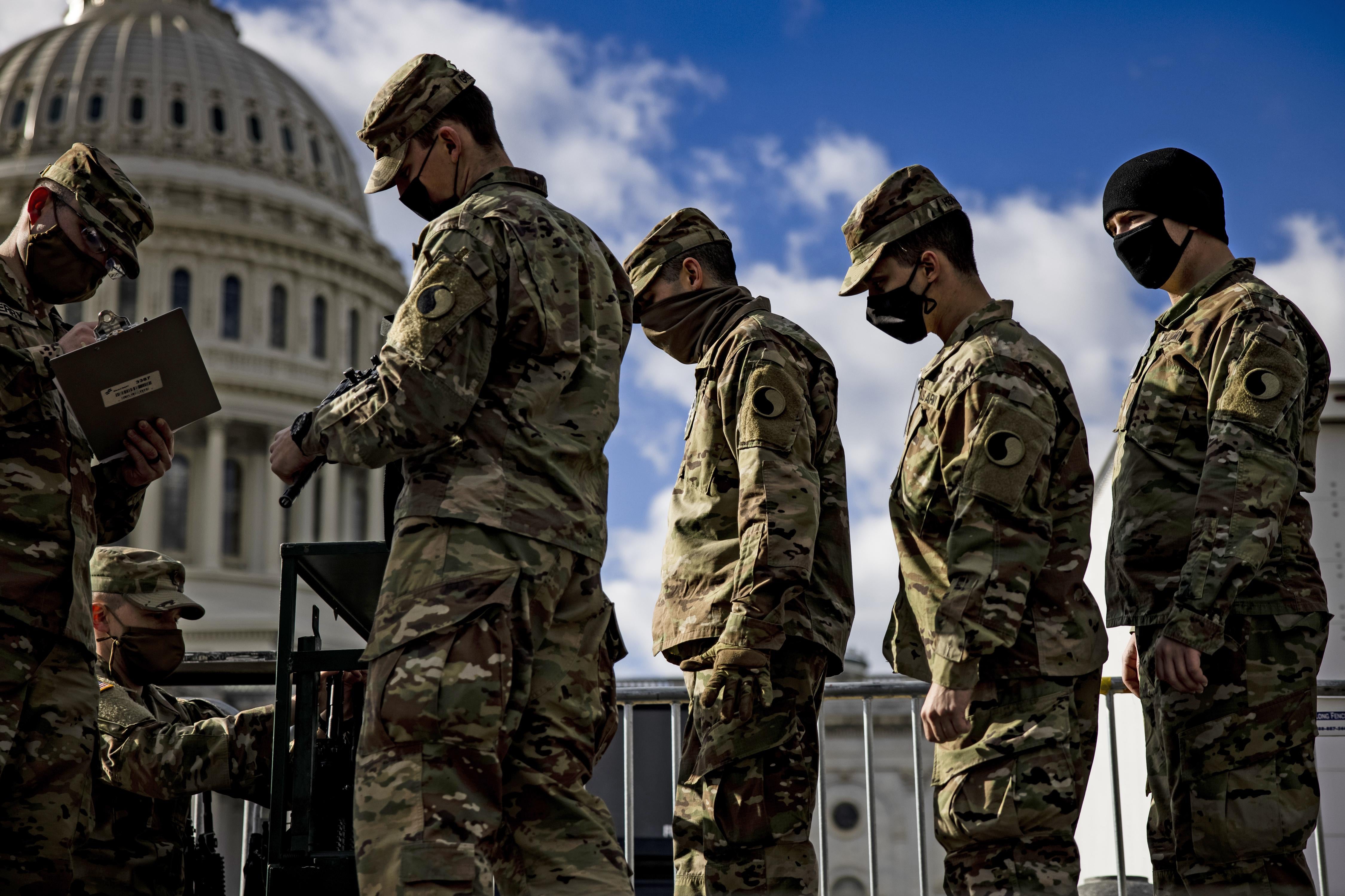 National Guardsmen near the Capitol receive their weapons.