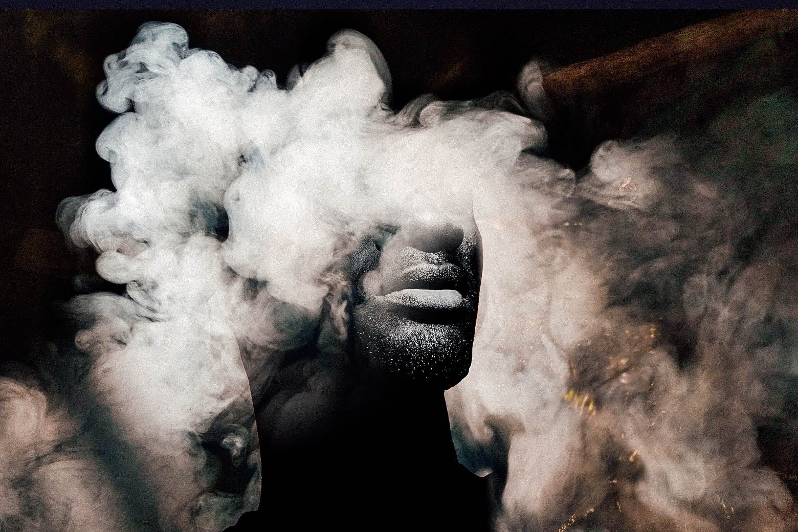 A black-and-white photo of a Black man surrounded in a cloud of smoke.