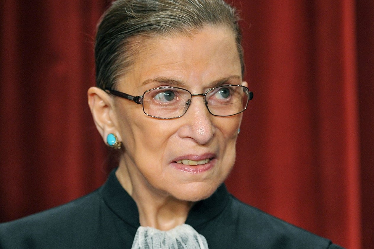 Ruth Bader Ginsburg in front of a red curtain at the Supreme Court.