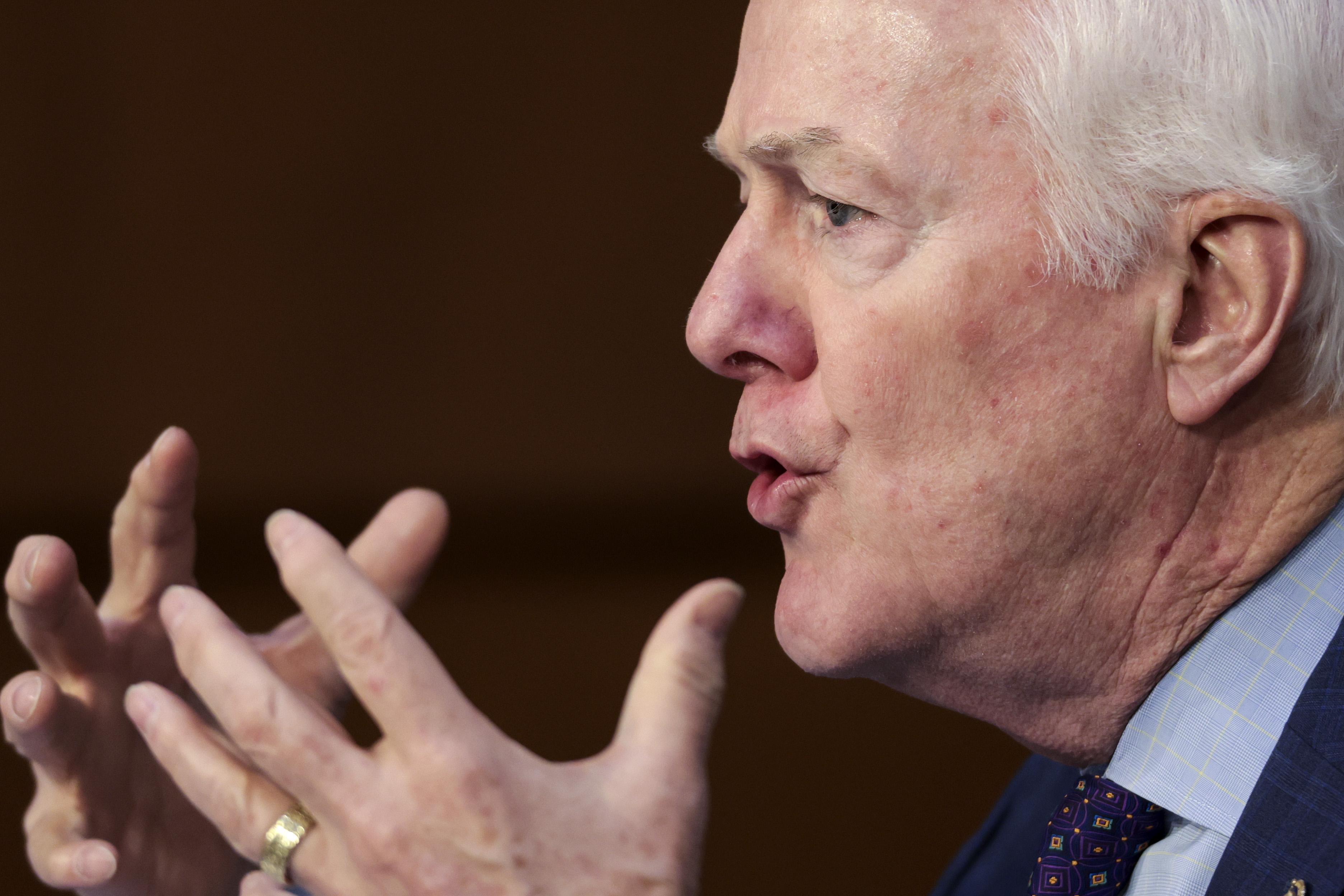 Cornyn holding up his hands and looking exasperated.
