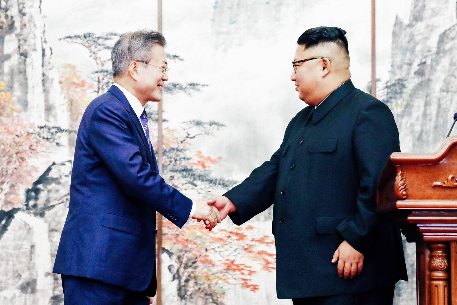 Moon Jae-in and Kim Jon-un shake hands.